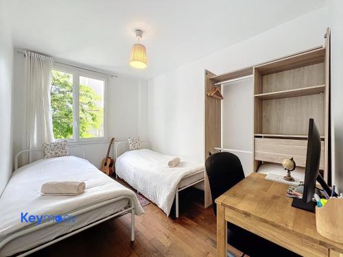 une chambre avec deux lits et un bureau avec un ordinateur dans l'établissement Lumineux 3 pièces proche Paris, à Ivry-sur-Seine
