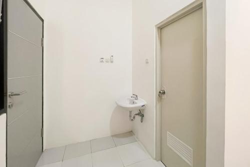 a white bathroom with a sink and a shower at RedDoorz at Pandu Raya Bogor by Madam M Place in Kalibata 1