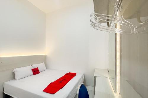 a small room with a bed with a red blanket on it at RedDoorz at Pandu Raya Bogor by Madam M Place in Kalibata 1