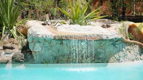 a waterfall in the middle of a pool at Suarez Hotel in Diego Suarez