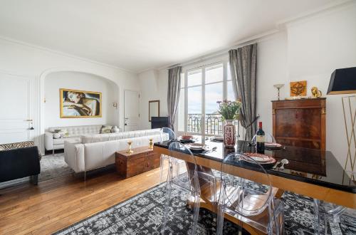 un salon avec un canapé blanc et une table dans l'établissement Champs Elysées I Vue sur Tour Eiffel & Spacieux, à Paris