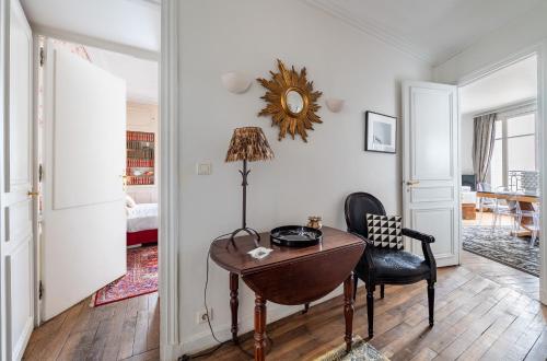 une pièce avec un bureau, une chaise et un miroir dans l'établissement Champs Elysées I Vue sur Tour Eiffel & Spacieux, à Paris
