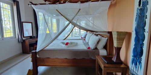 a bedroom with a bed with a canopy at Beautiful Secluded 8 bedroom Beach Villa with Pool in Makunduchi