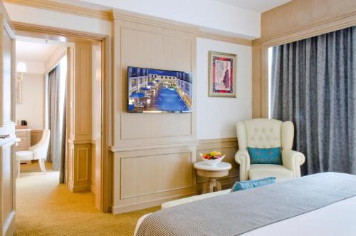 a hotel room with a bed and a chair at Royale Chulan Penang in George Town