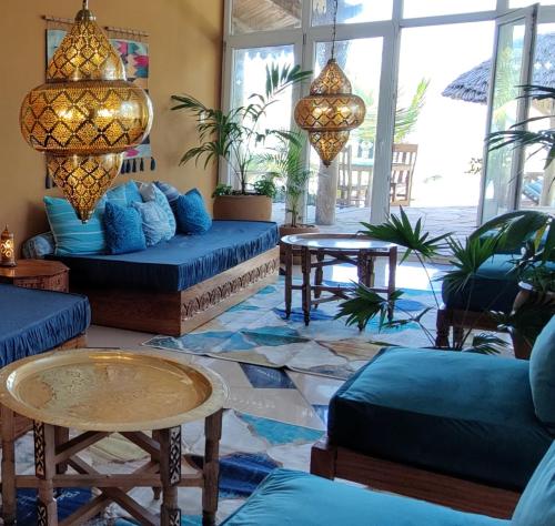 a living room with blue couches and a table at Beautiful Secluded 8 bedroom Beach Villa with Pool in Makunduchi