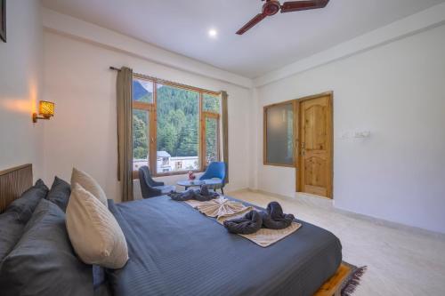 a bedroom with a large bed and a couch at Palm Residency, Kasol in Kasol