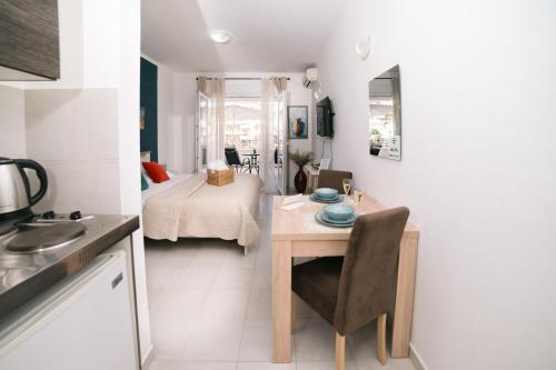 a kitchen with a table and a bedroom with a bed at The Rooftop of Apartments Lungo Mare in Ulcinj