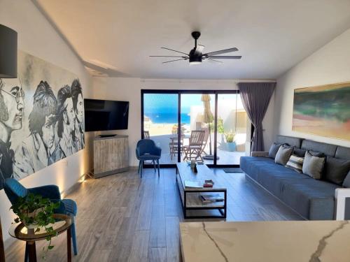 a living room with a blue couch and a tv at Unit 216-Casa Ricardo-Ocean View RENOVATED in Cabo San Lucas