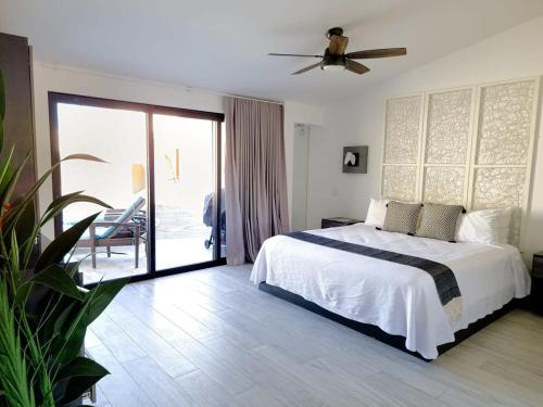 a bedroom with a bed and a sliding glass door at Unit 216-Casa Ricardo-Ocean View RENOVATED in Cabo San Lucas