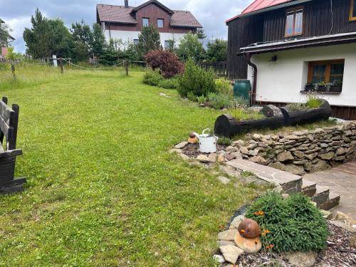a yard with a garden with a stone wall at Chata Betty Kvilda in Kvilda