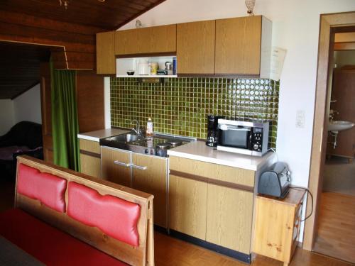 Una pequeña cocina con fregadero y microondas. en Chalet in Sankt Johann near Ski Lift, en Wagrain