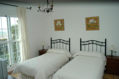 a bedroom with two beds and a window at Hotel restaurante El Duque in Medina Sidonia