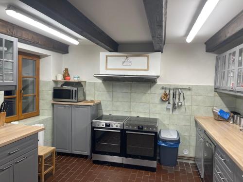 a kitchen with a stove and a microwave at Chata Betty Kvilda in Kvilda