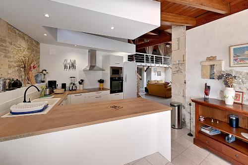 une cuisine avec des armoires blanches et un comptoir dans l'établissement Les Vents de Gironde - Maison en pierre piscine, à Chenac Saint Seurin D'uzet