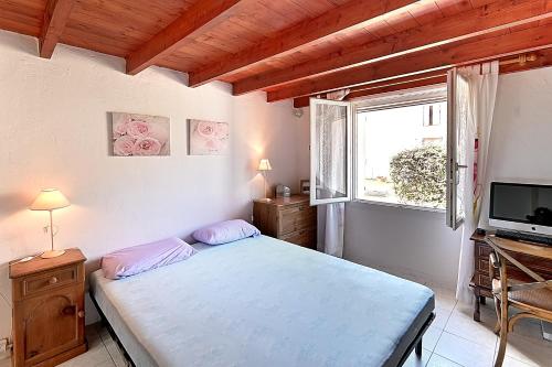 une chambre avec un lit, une télévision et une fenêtre dans l'établissement Les Vents de Gironde - Maison en pierre piscine, à Chenac Saint Seurin D'uzet