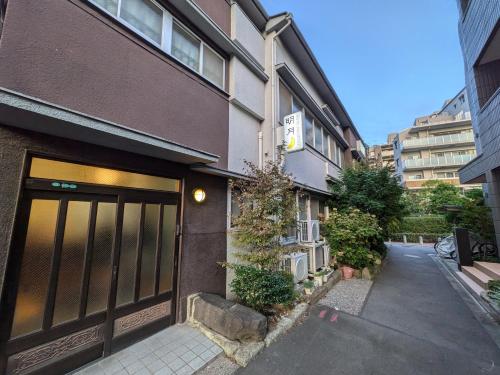 a brown building with a door on a street at Hotel Meigetsu in Tokyo