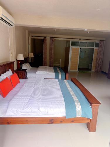 a large bed in a room with red and blue pillows at Amanda Villa - Best Value Mountain top Inn in Au Cap