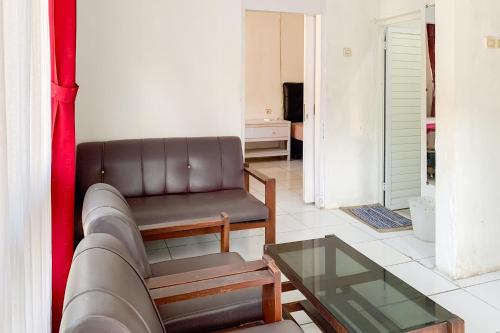 a living room with a couch and a glass table at Reddoorz at Hotel Bahagia Pangandaran in Pangandaran