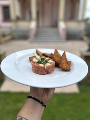 a person holding a plate with a dessert on it at Hotel Zámeček Raspenava in Raspenava