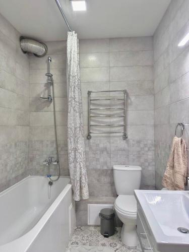a bathroom with a tub and a toilet and a sink at Sisters apartment Shevchenko in Chernihiv