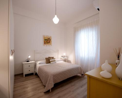 a white bedroom with a bed and a window at Frog 30 in Gabicce Mare