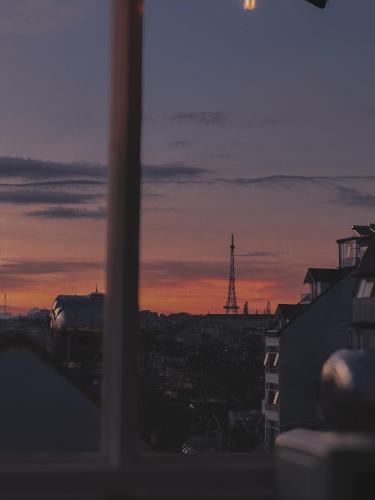 a view of a sunset from a window with a tower at L'amour Stay Dalat in Xuan An