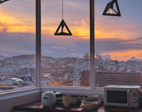 a kitchen counter with a window with a view of a city at L'amour Stay Dalat in Xuan An