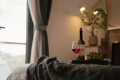 a bottle of wine and a glass of grapes at L'amour Stay Dalat in Xuan An