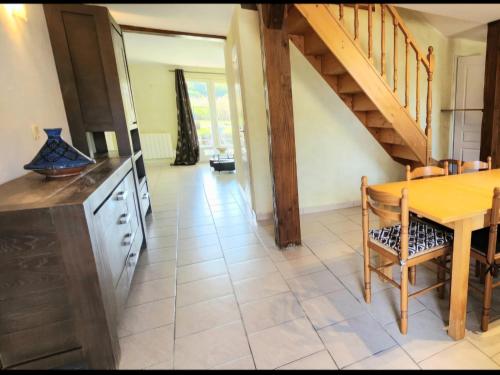 a kitchen and dining room with a table and a staircase at LOCATIONS RIVES DE SEUGNE - Claveau in Jonzac