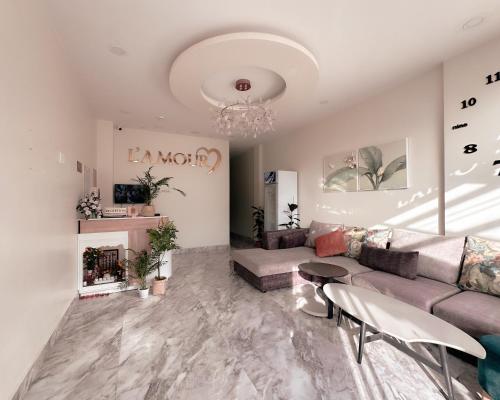 a living room with a couch and a chandelier at L'amour Stay Dalat in Xuan An