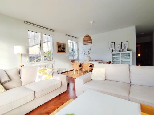 a living room with two white couches and a table at Sobre la Ría in Viveiro