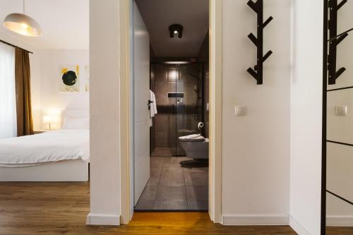a bedroom with a bed and a bathroom with a toilet at Townhouse Boutique in Sibiu