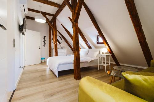 a attic bedroom with a bed and a couch at Townhouse Boutique in Sibiu