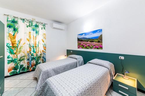 two beds in a room with flowers on the wall at Bed Room da Zio Tore in Ottana