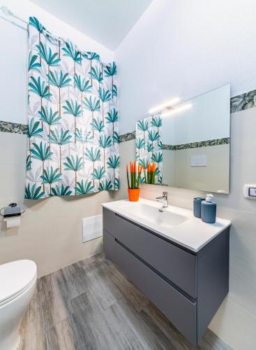a bathroom with a sink and a toilet and a mirror at Bed Room da Zio Tore in Ottana