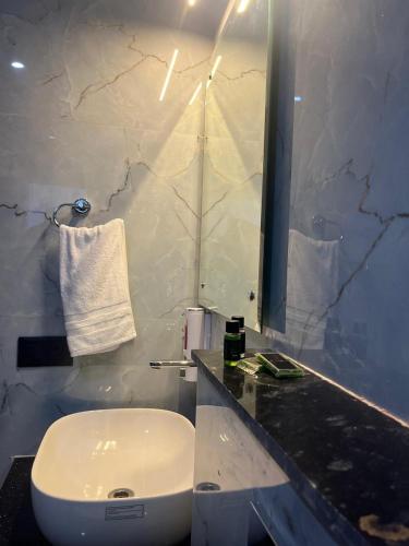 a bathroom with a white sink and a mirror at The Crown Prince in Greater Noida