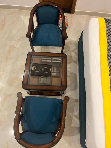 two chairs and a bed with a radio on it at The Crown Prince in Greater Noida