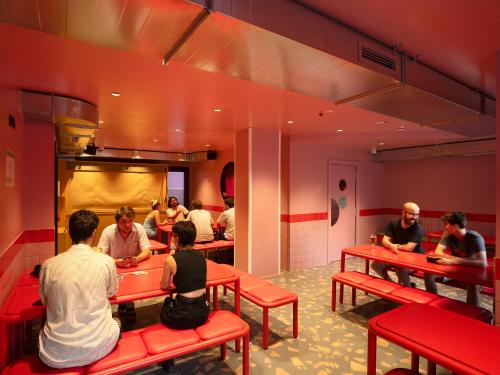 a group of people sitting at tables in a restaurant at AMISTAT City Hostel Barcelona in Barcelona