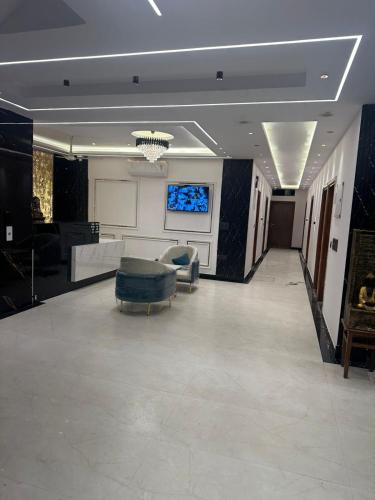 a large living room with a couch and a tv at The Crown Prince in Greater Noida