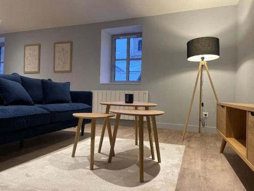 a living room with a blue couch and a table at Appartement plein centre, garage recharge voiture in Langres