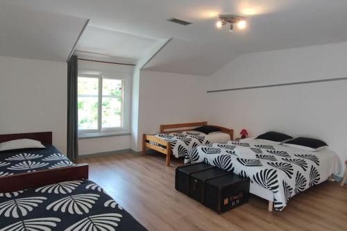 une chambre avec trois lits et une fenêtre dans l'établissement Grande maison familiale la bastide du puech, à Cransac