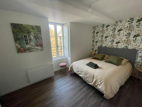une chambre avec un grand lit dans une pièce dans l'établissement Maison de ville- quartier calme, à Vitré