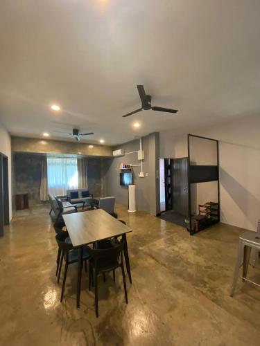 a living room with a table and chairs and a ceiling fan at JW Homestay (ShopHouse Lv2) in Kudat