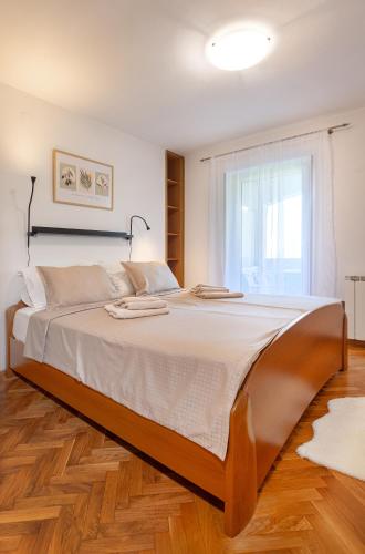 a large bed in a room with a window at House Olive Garden Strunjan in Strunjan