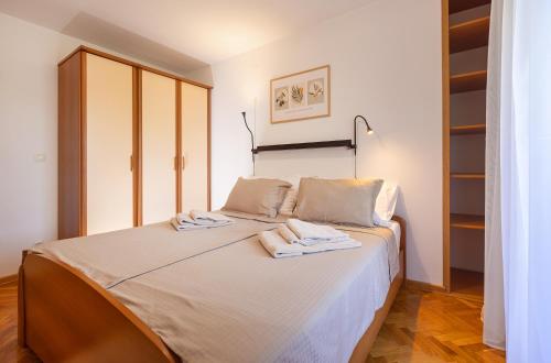 a bedroom with a bed with towels on it at House Olive Garden Strunjan in Strunjan