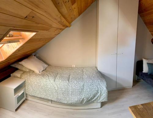 une chambre avec un lit et un plafond en bois dans l'établissement Studio à louer à 1 h de Paris, à Montereau-faut-Yonne