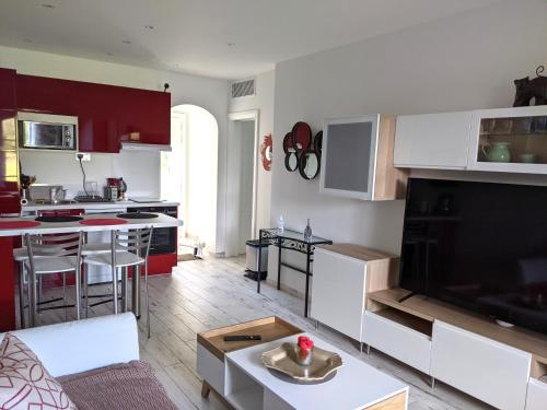 Il comprend une cuisine et un salon avec des placards rouges et blancs. dans l'établissement Joli F2 Saint Endreol HAMEAU PALAYSON Var, à La Motte