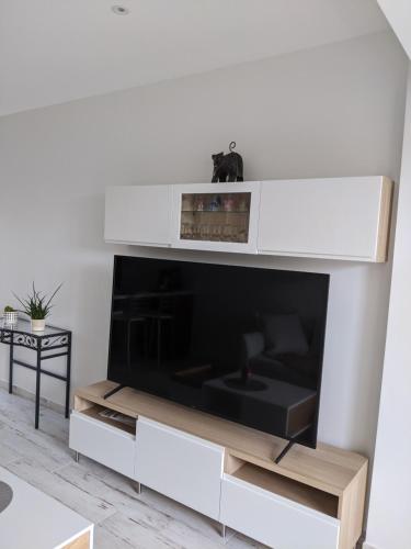 - un salon blanc avec une grande télévision dans l'établissement Joli F2 Saint Endreol HAMEAU PALAYSON Var, à La Motte