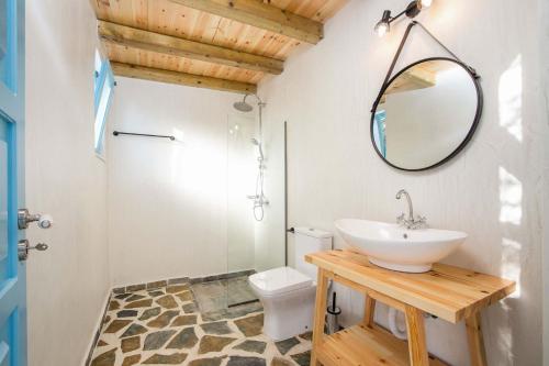 a bathroom with a sink and a mirror and a toilet at Villa Kalathos Dream Galazio in Kalathos
