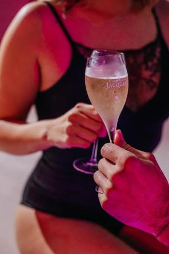 une femme tient un verre de vin dans l'établissement La Favorite - Love-Room Sensuelle, à Amboise